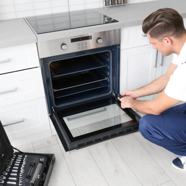 Young,Man,Repairing,Oven,In,Kitchen
